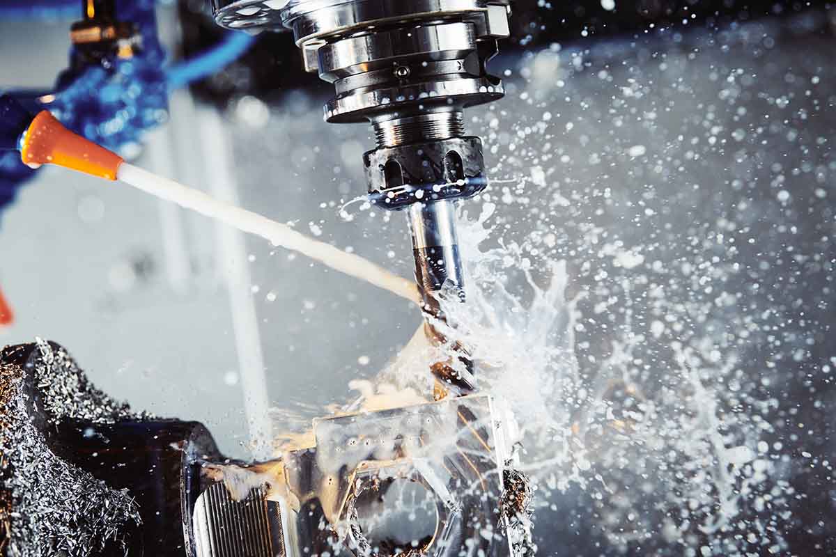 Milling metalworking process. Industrial CNC metal machining by vertical mill. Coolant and lubrication